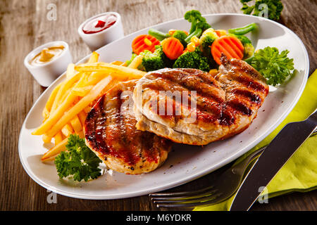 Gegrillte Steaks, Pommes frites und Salat Stockfoto