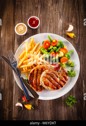 Gegrillte Steaks, Pommes frites und Salat Stockfoto