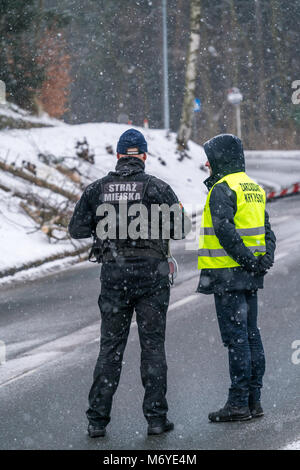 Karpacz, Polen - Februar 2018: Polizisten, Guardia Civil auf der Straße Sperrung des Verkehrs aus Sicherheitsgründen nach starker Schneefall Stockfoto