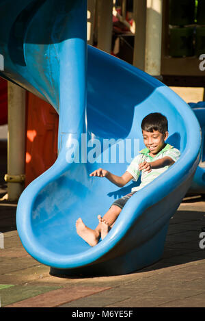 Vertikale Porträt eines Jungen auf der Folie in Viharamahadevi Park, früher als Victoria Park in Colombo, Sri Lanka bekannt. Stockfoto