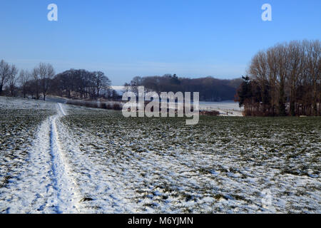 Fußweg über verschneite Feld am Ortsrand von Brabourne Lees, Ashford, Kent, Vereinigtes Königreich Stockfoto