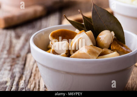 Hausgemachte eingelegte Pilze auf rustikalen Holztisch, vegetarische Kost Stockfoto