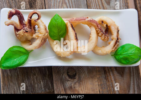 Frittierte calamari Ringe auf weißem Fach und Salat Stockfoto