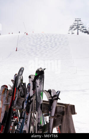 Paar Ski in einem Rack am unteren Rand eine Skipiste mit Sessellift und Buckelpiste in der Nähe von Morzine Les Gets Haute Savoie Portes du Soleil Frankreich Stockfoto