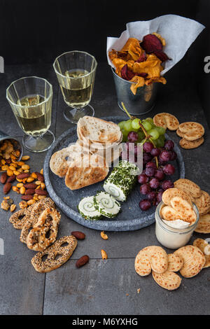 Cremige Käse mit Baguette, Cracker und Muttern mit Weißwein Stockfoto