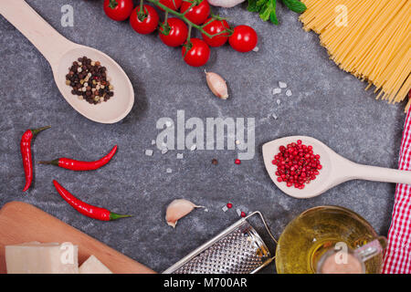 Traditionell das italienische Essen Hintergrund, mit Spaghetti, Parmesan, Olivenöl, Knoblauch, Pfeffer, Rosmarin, Tomaten, Petersilie und Thymian. Stockfoto
