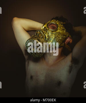 Mann mit Gold Gas Mask und Arabesken in Posen der ertrinken und Verzweiflung, Depression und Psychiatrie Konzept. Stockfoto