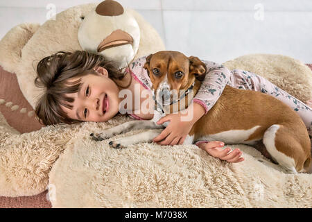 Sechs Jahre alten Mädchen und Ihr Hündchen Festlegung auf einen riesigen Bären Stockfoto