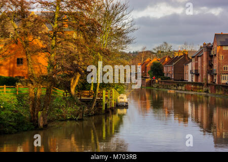 Ein Blick auf den Fluss Wensum in Norwich in der herbstlichen Sonne mit Häuser säumen die Ufer und einem einzigen Boot Stockfoto