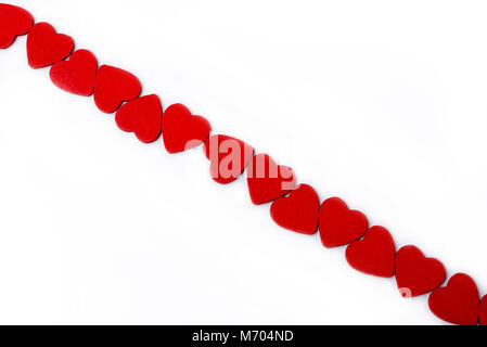 Valentine Hintergrund mit genähten Kissen Herz Zeile Grenze auf weißem Holz Hintergrund. Getönt, Herz geformten diagonal. Stockfoto