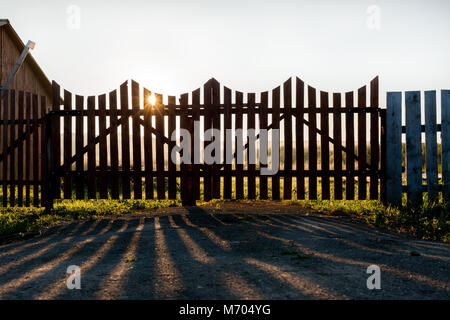 Sonne scheint durch hölzerne Tor in der Morgendämmerung im Sommer. Stockfoto