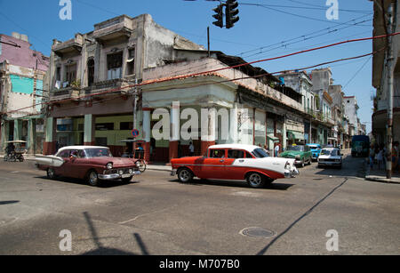 Zwei klassische restaurierte alte amerikanische Autos fahren auf den belebten Straßen des Centro Havana in Kuba Stockfoto