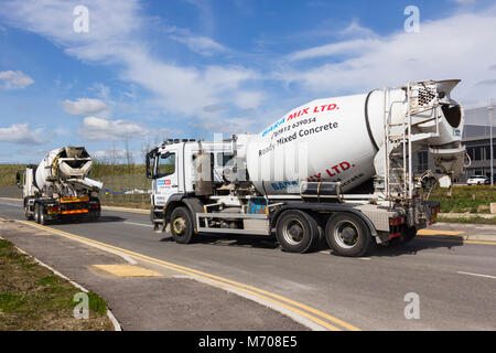 Zwei Baramix Betonmischanlagen Lkw, aka Beton Lkw, verlassen die Baustelle bei Logistik und Vertrieb Nord Business Park. Stockfoto