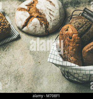 Verschiedene Brot Brote auf grauem Beton Hintergrund, Quadrat Erntegut Stockfoto