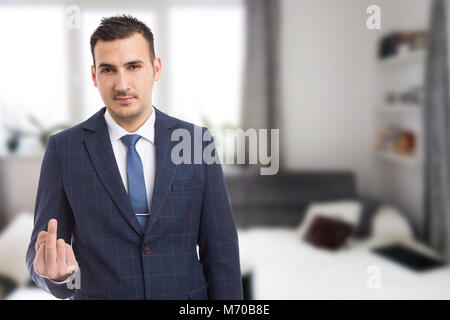 Real estate agent zeigt Mittelfinger drinnen im Haus Wohnbereich Stockfoto