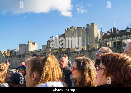 Touristen versammelt Hören zu einem beefeater Tour Guide, Tower of London, Tower Hill, London UK touristische Konzept, Touristen hören zu einem Leitfaden Stockfoto