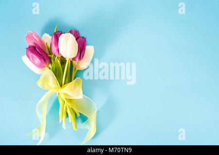 Flach der Bündel von lila Tulpen auf hellen blauen Hintergrund. Kopieren Sie Platz. Stockfoto