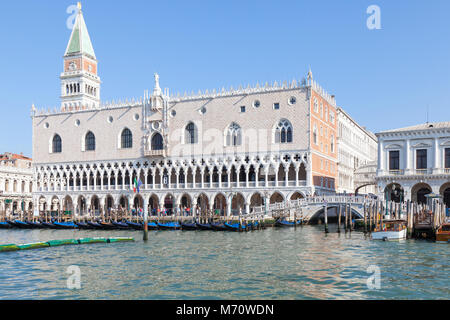 Der Dogenpalast, San Marco in der frühen Morgensonne, Venedig, Venetien, Italien gesehen in der Nähe von der Lagune in St Marks Becken mit angelegten Gondeln ein Stockfoto