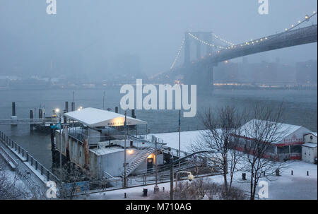 Die barge genannt Bargemusic, Ferry Station, die Brooklyn Bridge, den East River und die Skyline von Manhattan als von Dumbo in einem Schneesturm, Nor'easter Stockfoto