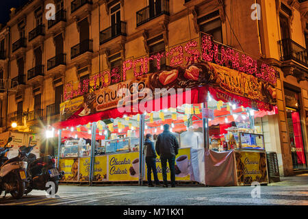 VALENCIA, Spanien - 3/7/2018: In der Nacht auf den Straßen der Stadt von Valencia, Spanien eines der vielen Churros con chocolate steht, während die Cel Stockfoto