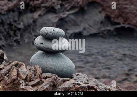 Ein Stapel von ausgewogenen Kiesel oder Cairn am schwarzen Strand von El Golfo, Lanzarote, Spanien Stockfoto