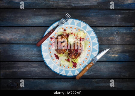 Türkei Schnitzel mit frischen Beeren und saucea Eisberg Salat mit Besteck serviert. Stockfoto