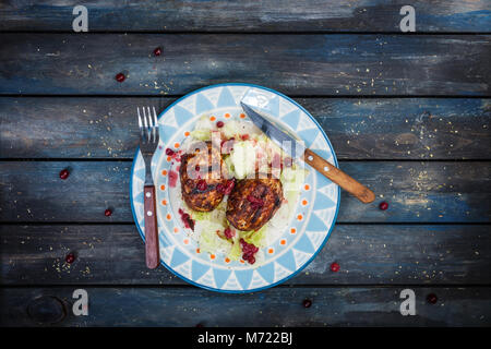 Türkei Schnitzel mit frischen Beeren und saucea Eisberg Salat mit Besteck serviert. Stockfoto