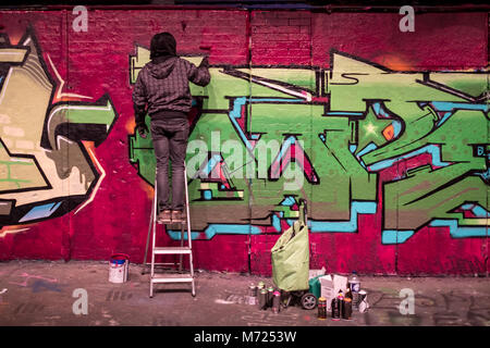 Man steht auf einer Leiter, Graffiti, Leake Street, London, in der Nähe der Waterloo Station. Stockfoto