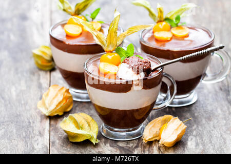 2-in-1-Dessert mit Physalis auf hölzernen Tisch Stockfoto