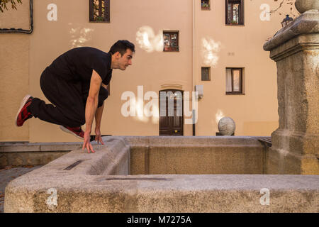 Junger Mann, eine ehrfürchtige parkour Sprung auf die Straße. Stockfoto