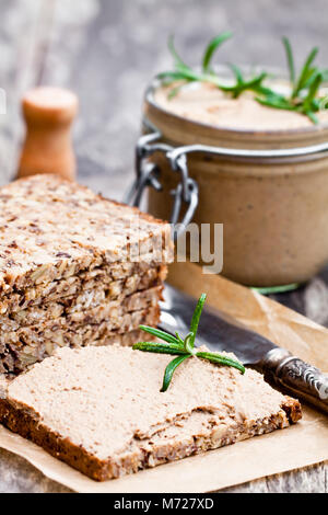 Homemadeliver Pastete mit Rosmarin in einem Glas auf einem rustikalen Holztisch Stockfoto