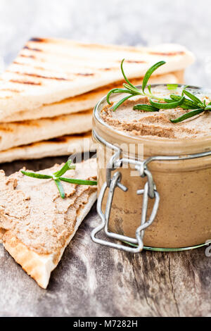 Homemadeliver Pastete mit Rosmarin in einem Glas auf einem rustikalen Holztisch Stockfoto