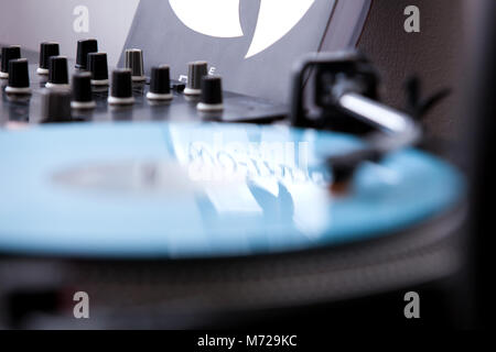 Ein Detail einer blauem Vinyl spielen auf Plattenspieler, Mixer und eine Reflexion von Wu-Tang Handbuch Buch. Stockfoto