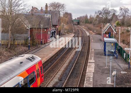 Eine Klasse 156 Diesel Multiple Unit Train durch die ländliche Station bei Sankey in Cheshire. East Midlands Trains Stockfoto