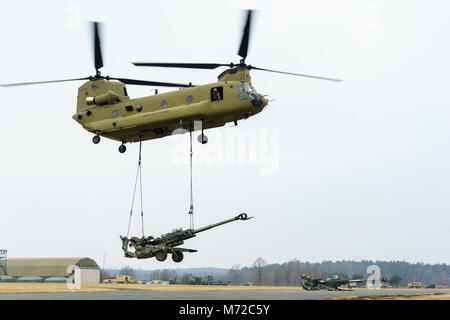 Eine CH-47 Chinook Hubschrauber Besatzung zu Unternehmen B zugeordnet sind, 2. Allgemeine Unterstützung Aviation Battalion, 227 Aviation Regiment, 1 Combat Aviation Brigade, 1.Kavallerie Division, Aufzüge ein M777 Haubitze, die Batterie B, Field Artillery Squadron, 2.Kavallerie Regiments, während Schlinge last Training auf einem Flugplatz in der Nähe von Grafenwöhr, Deutschland März 6, 2018. Soldaten der beiden Einheiten kamen zusammen, um Beziehungen zu Schulen und bei der dynamischen Front 18, eine jährliche US-Army Europe Übung zur Verbesserung der Interoperabilität der US-Armee, gemeinsamen Dienst stärken und Verbündete nation Artillerie und Feuer in einem Stockfoto