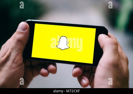 Köln, Deutschland - 27. FEBRUAR 2018: Nahaufnahme der männlichen Händen hält iPhone 5s Anzeigen SNAPCHAT Logo Stockfoto