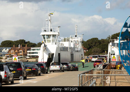 Fahrzeuge gehen an Bord der Fähre Poole Kette, von der North Side, Dorset UK, mit Sandbänke über dem Wasser Stockfoto