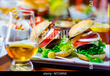 Mini Burger mit Fleisch, Gemüse, Käse und anderen Belag, Brot mit Sesam bestreut, mini Fast food, lecker einstellen Stockfoto
