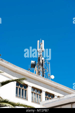 Handy Telekommunikation Antennen und Repeater auf Gebäude gegen blauen Himmel Stockfoto