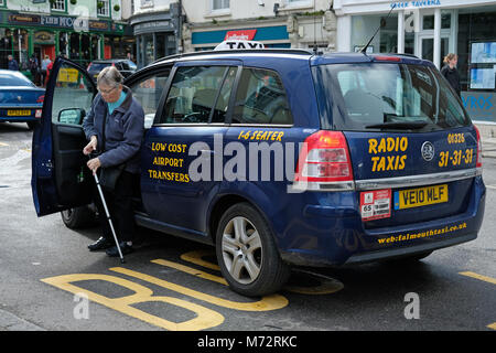 Eine Dame aus einem Mini cab oder Taxi in Cornwall. Stockfoto