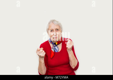 Böse alte Frau, die Fäuste auf weißem Hintergrund Stockfoto