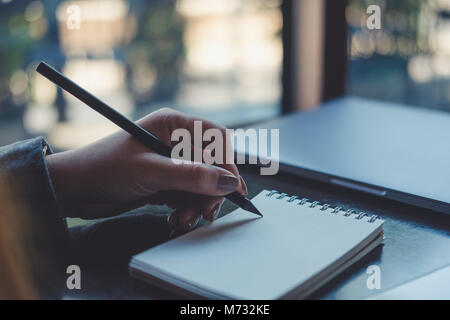 Closeup Bild der Hände einer Frau schreiben auf Notebook auf dem Tisch Stockfoto