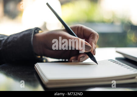 Closeup Bild der Hände einer Frau schreiben auf Notebook auf dem Tisch Stockfoto