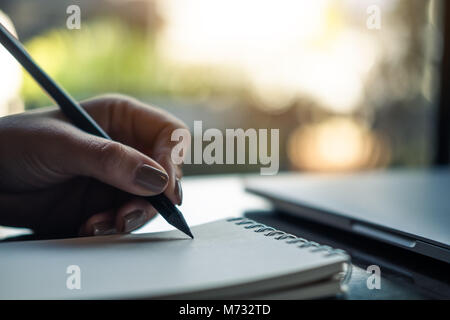 Closeup Bild der Hände einer Frau schreiben auf Notebook auf dem Tisch Stockfoto