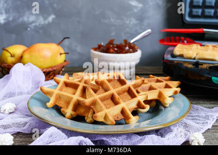 Knusprige golden vanilla Wafers mit pear Jam, elektrische Wafer Teller auf einem hölzernen Hintergrund. Stockfoto