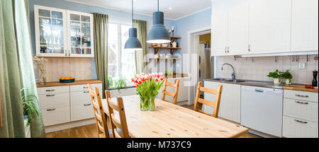 Küche Interieur mit Tulpen in der Vase auf dem Tisch galss Stockfoto