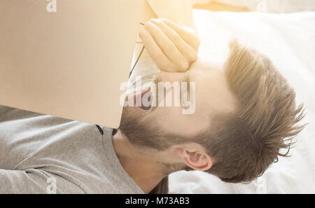 Der Mensch Schlaf im Bett, nachdem Buch lesen Stockfoto