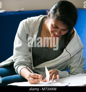 Eine weibliche 'A' Level Student an einer öffentlichen Schule Mädchen Englisch studieren in der Sixth Form gemeinsamen Zimmer vor einer Prüfung. Stockfoto