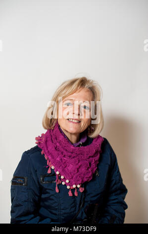 Porträt einer 65-jährigen Frau im Winter Kleidung, grauen Hintergrund, Studio shot Stockfoto