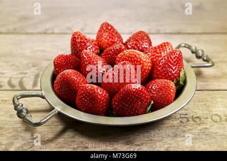 Leckere Erdbeeren auf einer metallischen Platte, die sich in einem grossen closeup Stockfoto